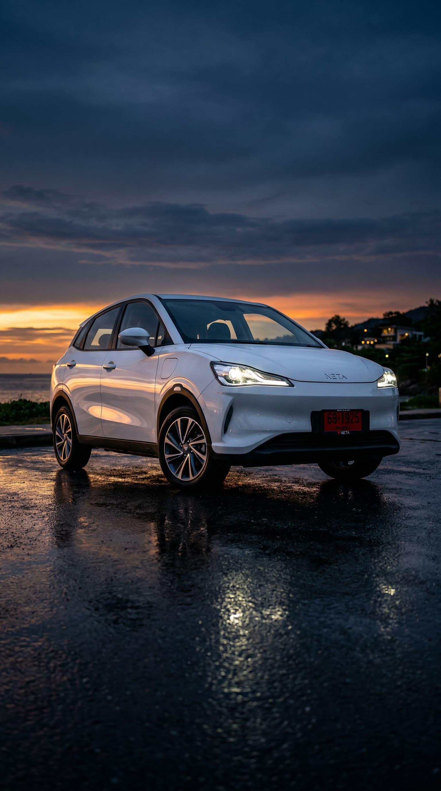 Neta V electric car on coastal road in Phuket at sunset